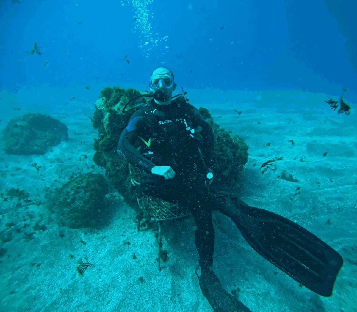 Eugen sitting on a chair on the sandy sea floor off Tenerife, in full scuba gear